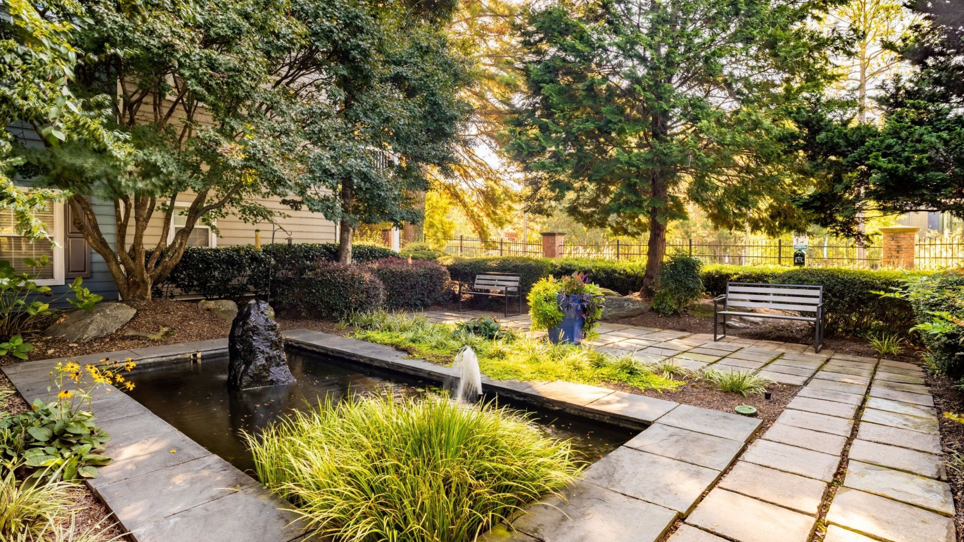 Hawthorne North Druid Hills outdoor koi pond garden space with benches and surrounding greenery